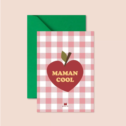 A postcard featuring a red and white gingham background with a large red apple illustration in the centre. The words "MAMAN COOL" are printed in bold, yellow vintage-style text inside the apple. The card is paired with a bright green envelope.