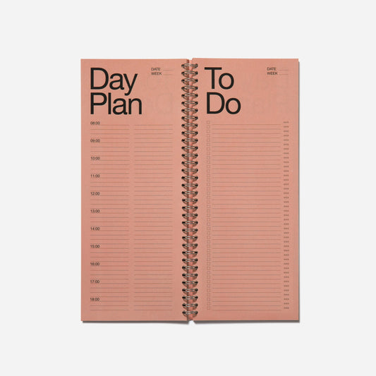 Pink spiral-bound planner with 'Day Plan' and 'To Do' sections on a white background