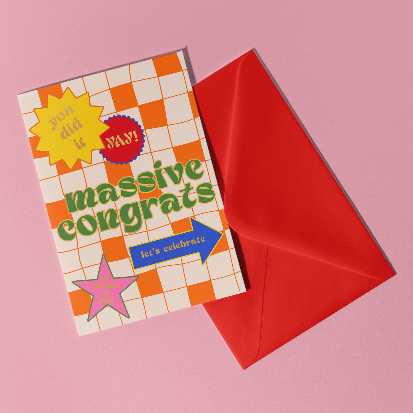 A pink background with a red envelope. The card is an orange checkerboard with differed coloured shapes and the words massive congrats in green