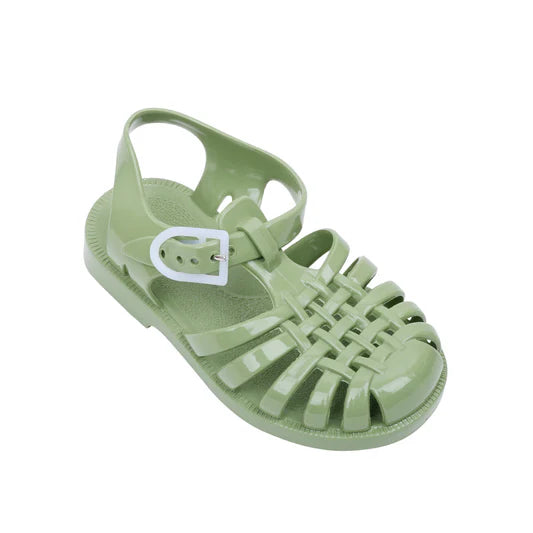 A top-down angled view of a single olive green Meduse jelly sandal with an adjustable white buckle and classic woven design.