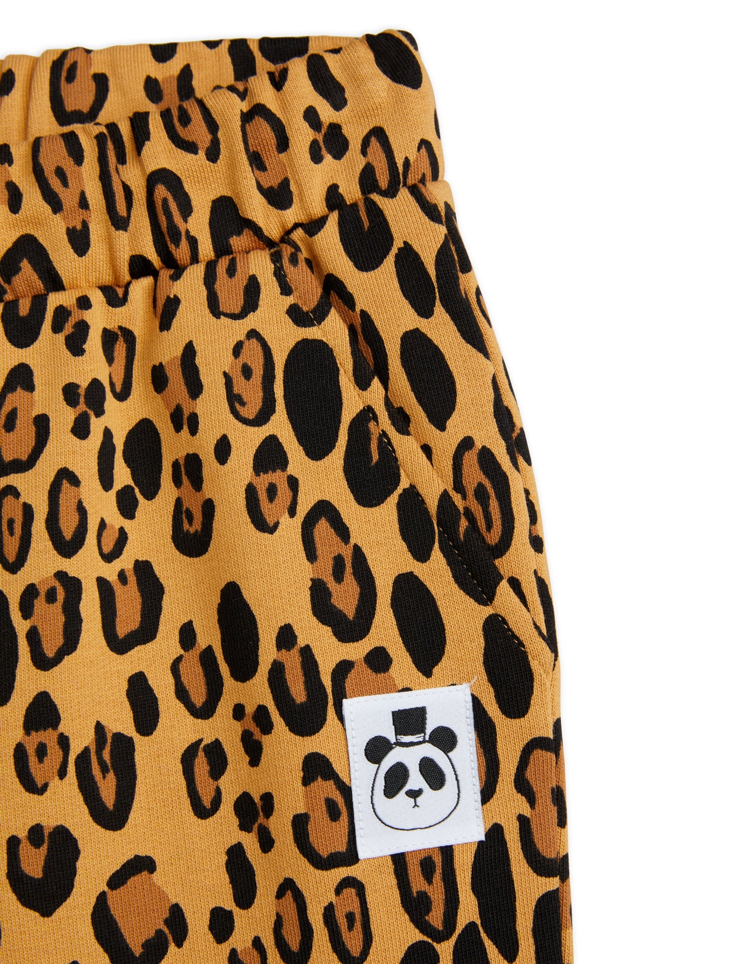 Mini Rodini sweatpants in an abstract leopard print all over pattern. on a beige base there is darker brown and black leopard pattern spots and a drawstring elastic waistband and pinched cuffs at the ankles