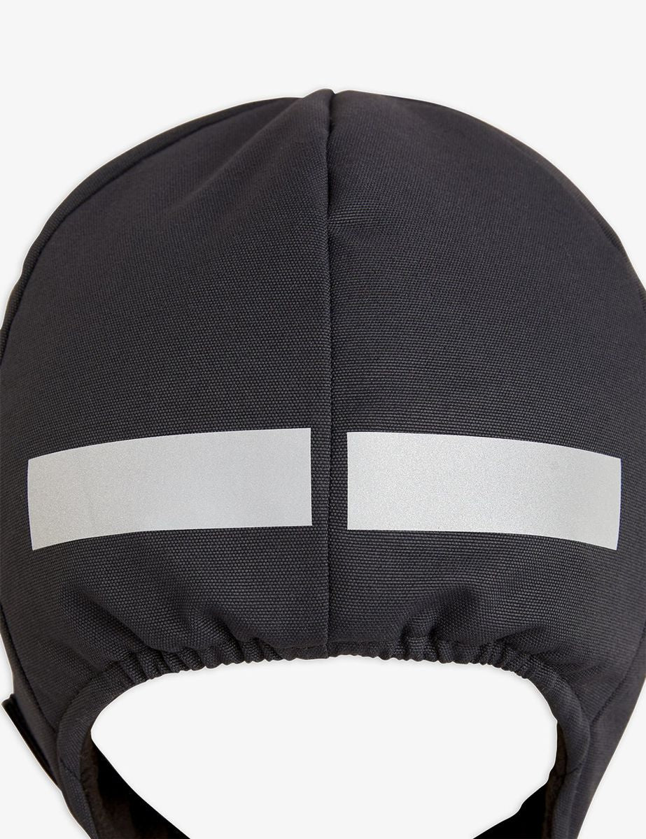 Close-up of the black Mini Rodini Alaska thermo-cap, featuring a cosy, quilted design made from 100% recycled polyester. The cap includes an embroidered Mini Rodini badge on the side and a water-repellent BIONIC-FINISH® ECO coating.