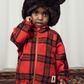 a child in the Mini Rodini children bright red with large check pattern fleece jacket, with a gold plated zip and two side pockets and a high neck