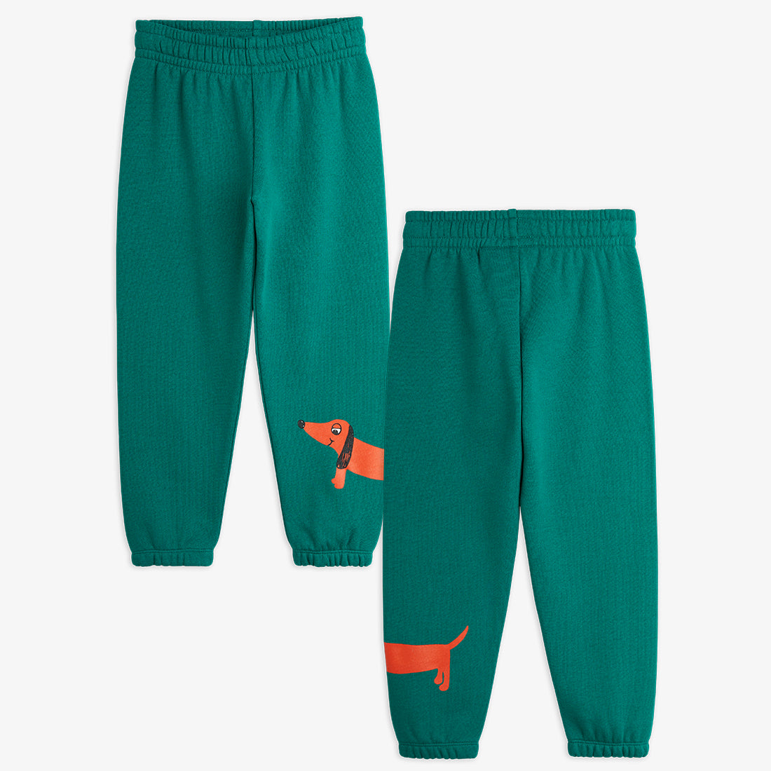 a pair of teal green mini rodini sweatpants with a printed red sausage dog on the bottom of the left leg. with an elasticated waistband and cuffs at the ankles