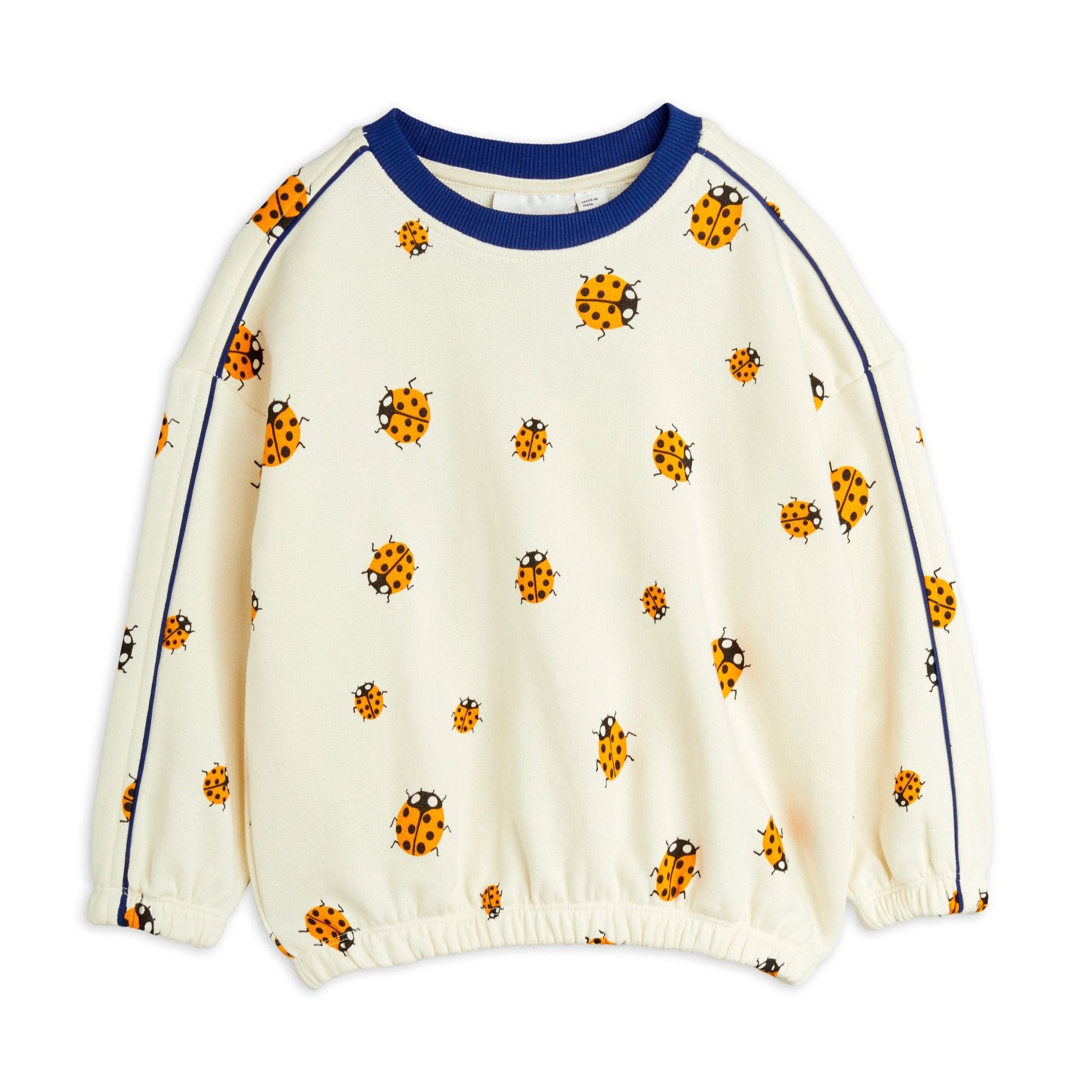 An off-white organic cotton kids' sweatshirt featuring an all-over ladybird print, contrast piping along the sleeves, and ribbed cuffs for a relaxed fit.