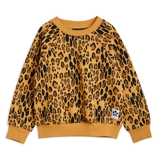  Leopard print Mini Rodini sweatshirt with long sleeves and a baggy fit. the leopard pattern is on a warm beige base with darker brown nd black leopard dots all over