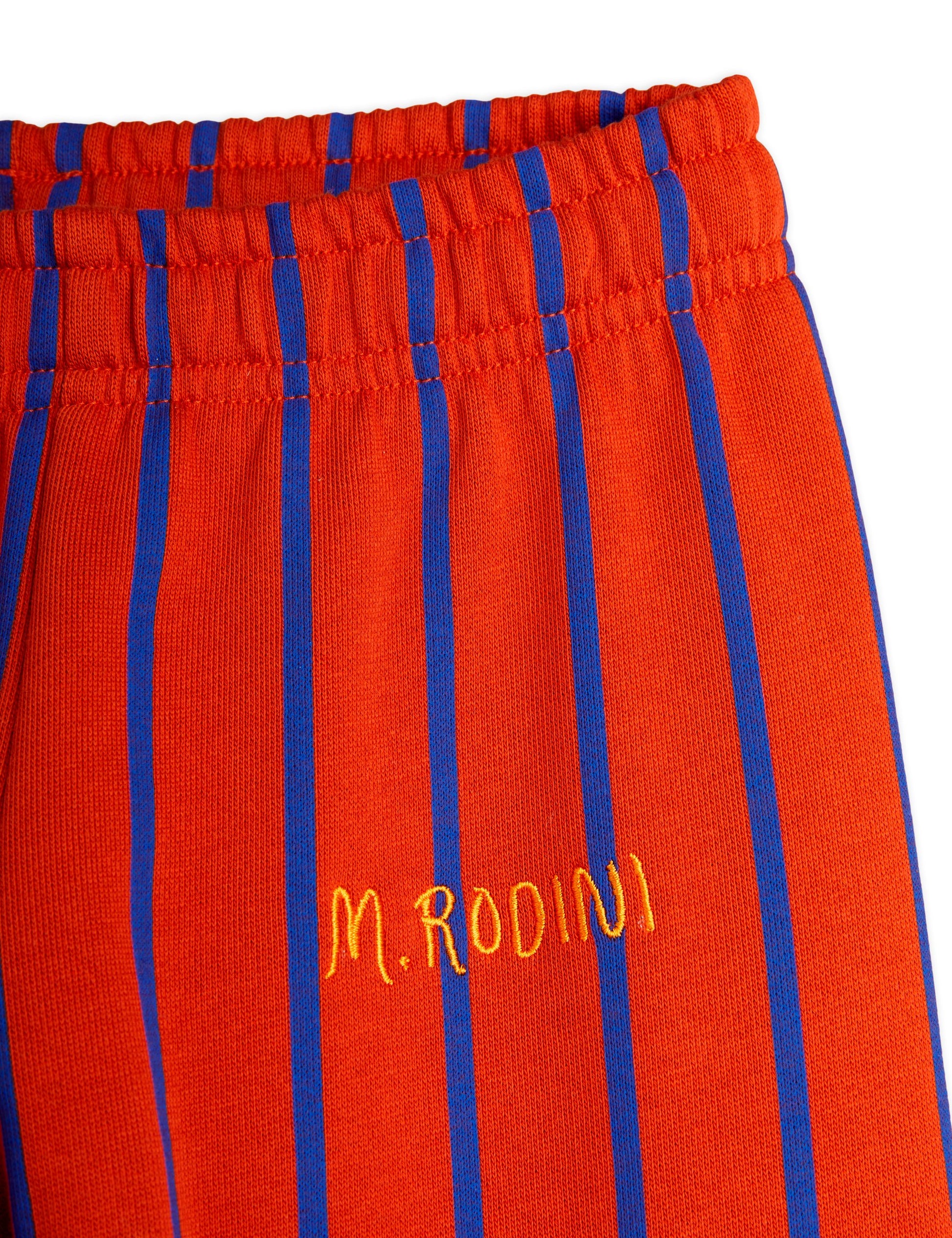 Detailed view of the Mini Rodini striped trousers, showing the elasticated waistband and the "M. Rodini" embroidered logo in yellow on the side.