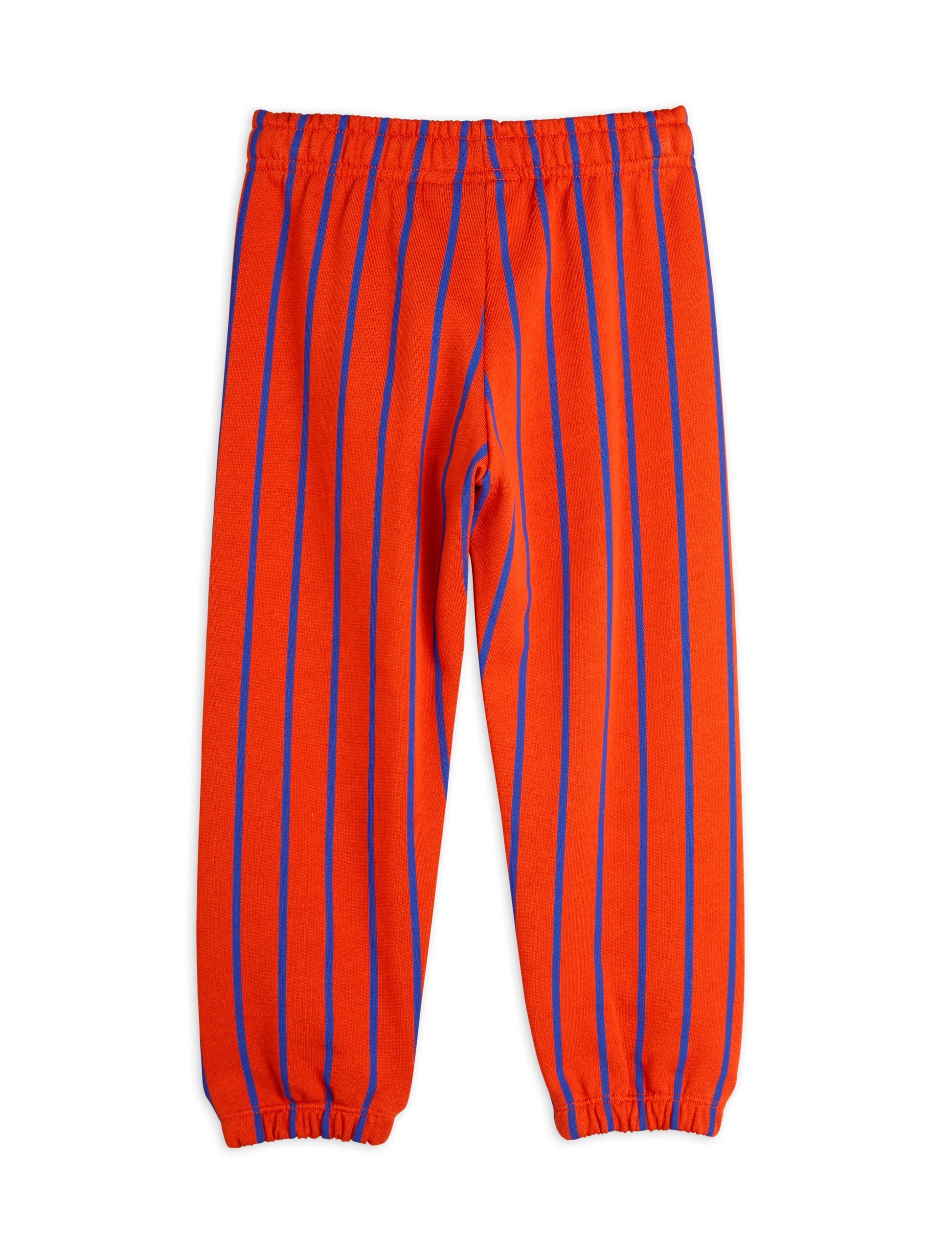 Mini Rodini striped trousers in a bold orange hue with contrasting blue vertical stripes. Designed with an elasticated waistband and elasticated cuffs for a relaxed fit.