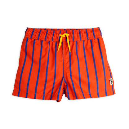 A pair of children's swim shorts in bold orange with vertical blue stripes. Designed with an elasticated waistband, bright yellow drawstring, and a small Mini Rodini logo patch on the side.