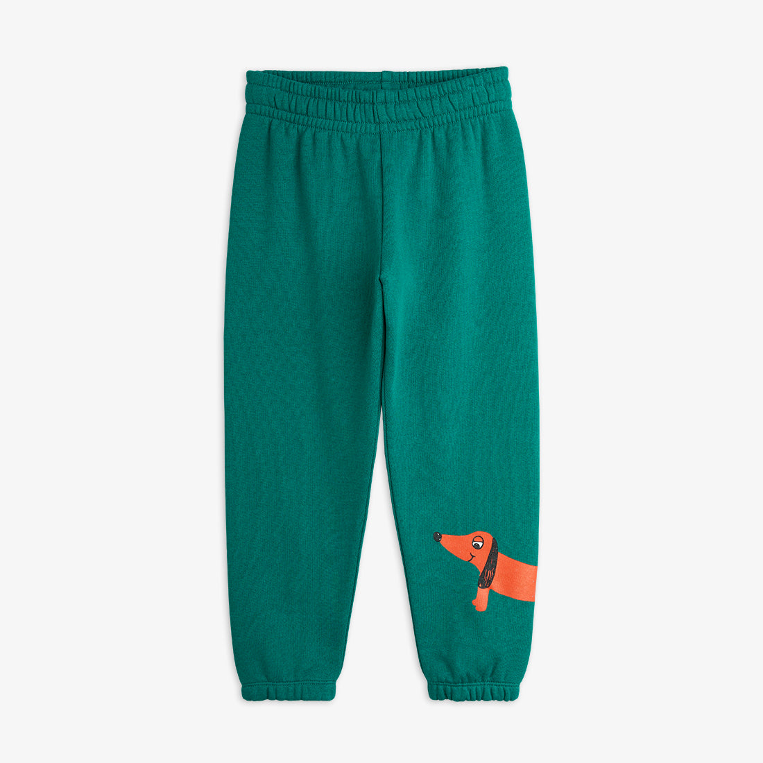 a pair of teal green mini rodini sweatpants with a printed red sausage dog on the bottom of the left leg. with an elasticated waistband and cuffs at the ankles