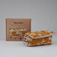 Wheat bag with floral pattern next to its packaging box on a gray background
