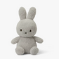 A Miffy Terry soft toy in the colour light grey. This Miffy has black eyes and mouth. Miffy is 23 cm in height. The background is white. 