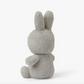 A Miffy Terry soft toy in the colour light grey. This Miffy has black eyes and mouth. Miffy is 23 cm in height. The background is white. This is the back side of Miffy 