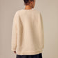 The Sideline Rosa Top shown from the back, highlighting its oversized silhouette and plush shearling texture. The design features a simple, clean line, emphasizing comfort and warmth. This view showcases the top’s versatility, making it an ideal choice for layering or wearing alone during colder months.