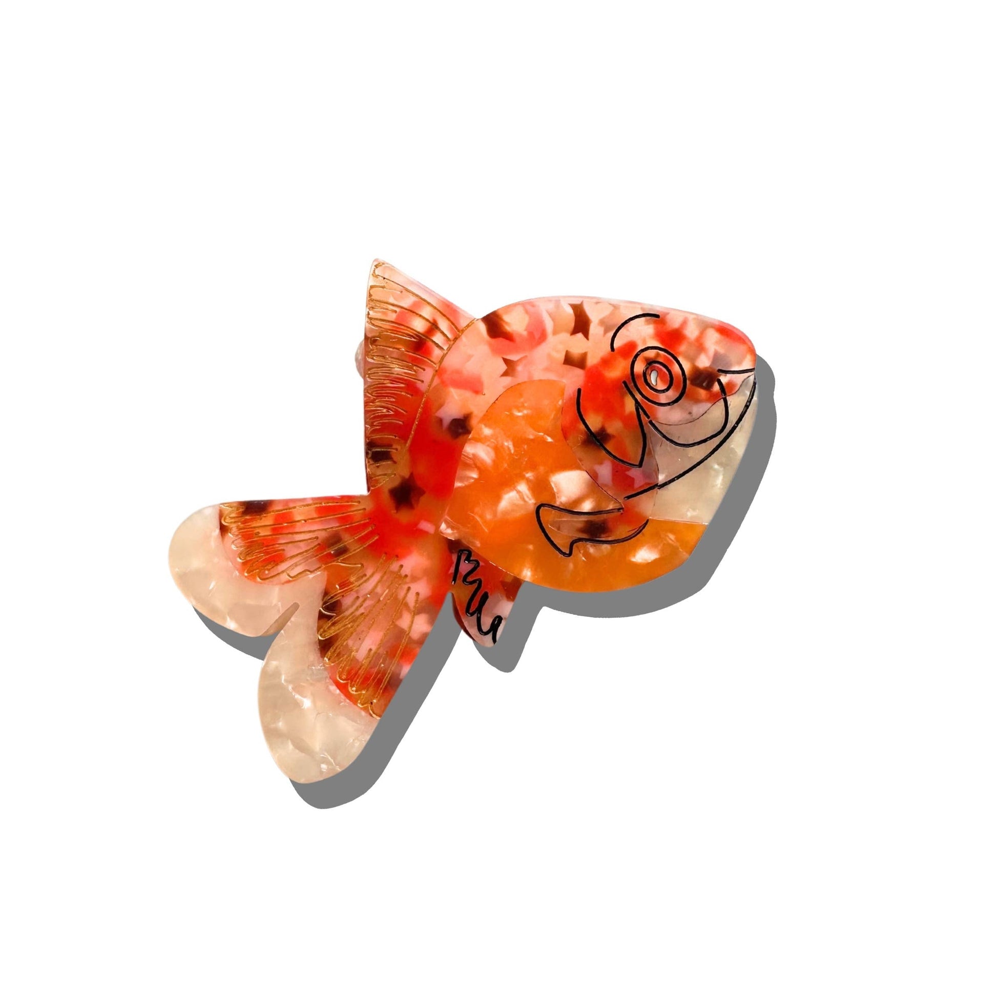 A goldfish-shaped hair claw with a marbled orange and white pattern, featuring delicate gold detailing and a hand-drawn fish illustration. The translucent design mimics the shimmer of real fish scales, and the clip casts a soft shadow on a white background