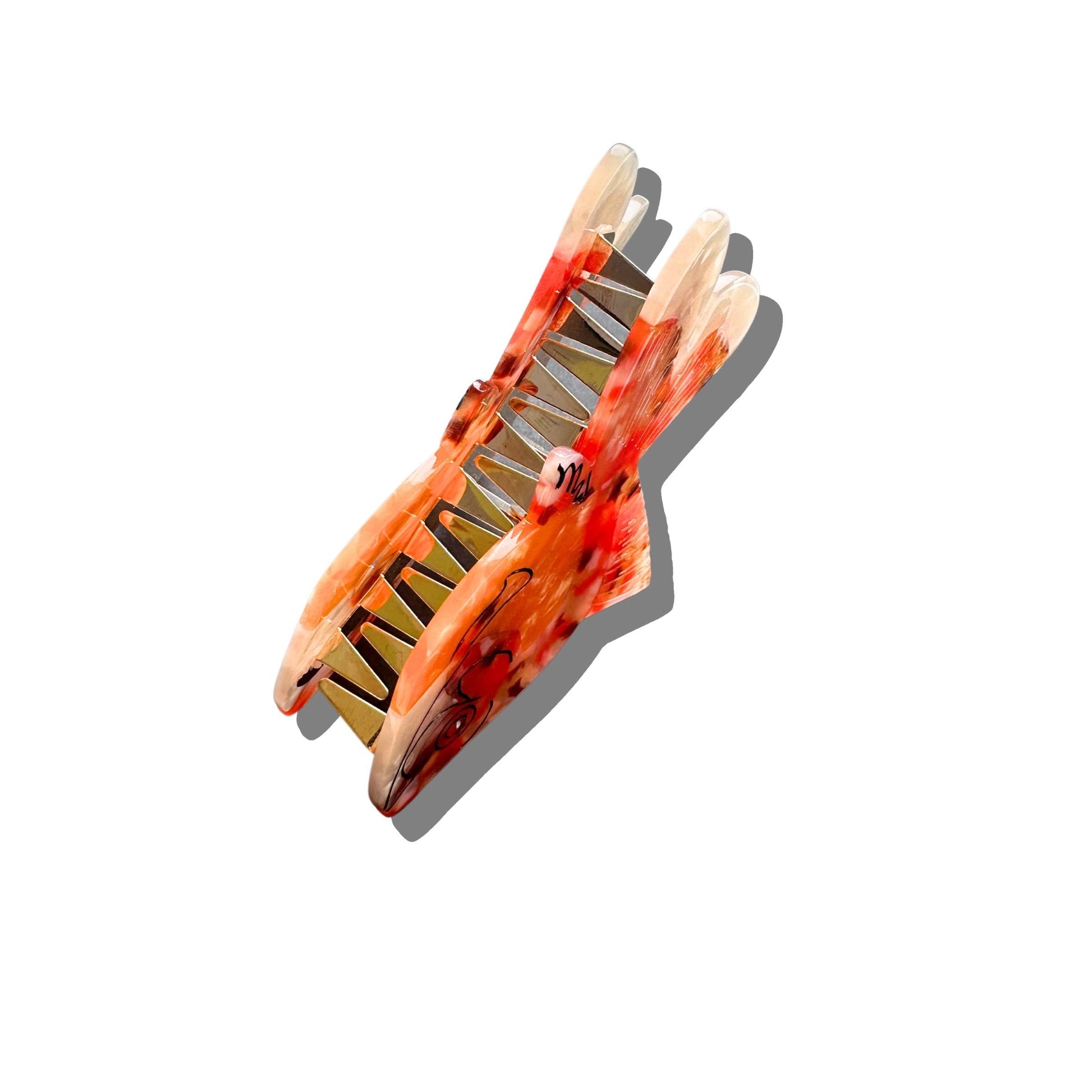 A side view of the goldfish hair claw, highlighting its curved grip and secure clasp. The translucent marbled orange pattern and intricate gold detailing give it a lifelike, aquatic-inspired appearance.