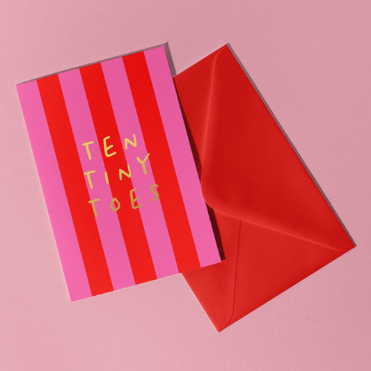 A red and pink vertical striped card with the words Ten Tiny Toes in gold foil lettering