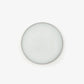 An overhead shot of a circular pot of the perfume balm against a white background. 