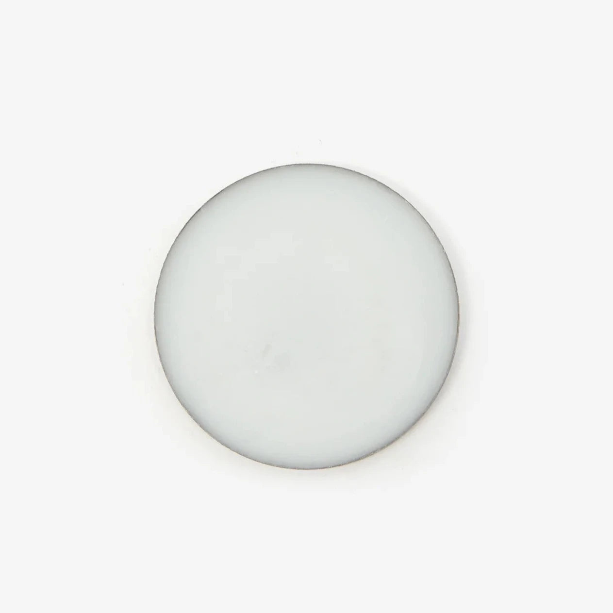 An overhead shot of a circular pot of the perfume balm against a white background. 