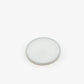 A circular pot of the perfume balm against a white background. 