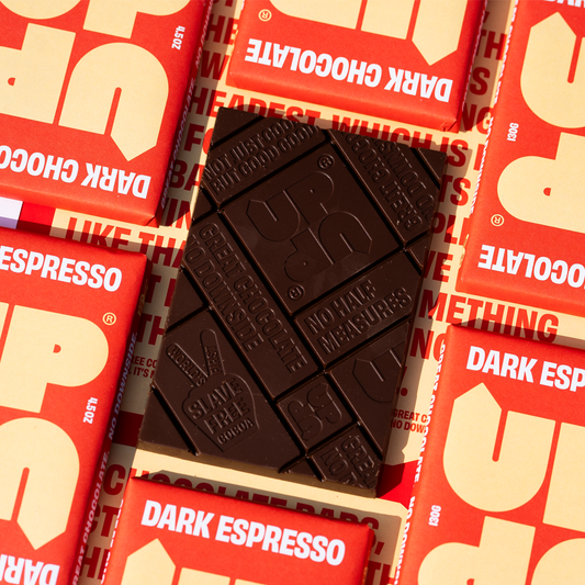 Dark chocolate bar on top of red and white UP UP Dark Chocolate packaging