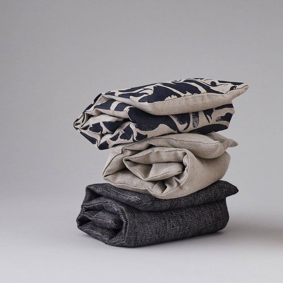 Stack of folded fabric wheat bags on a grey background