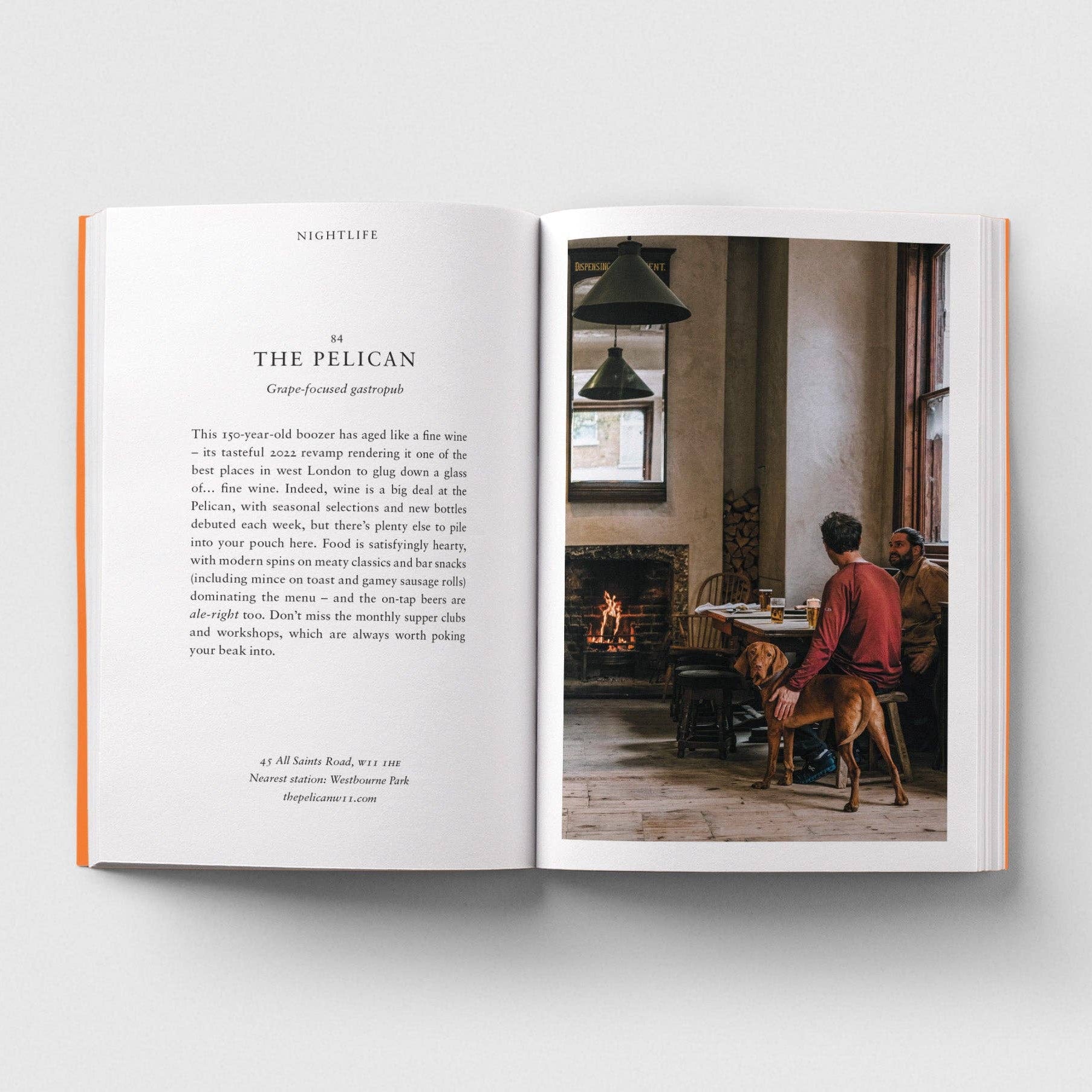 Open book showing a page with text and a photograph of a person with a dog in a room.