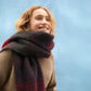 Person wearing a colorful scarf against a blue background