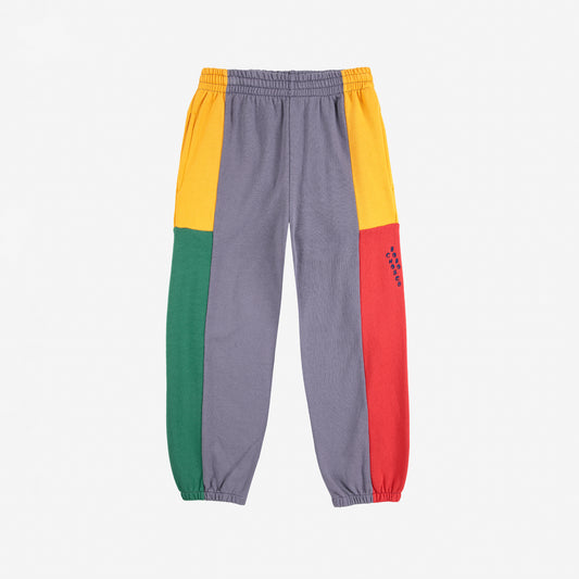 Color-blocked pants with gray, yellow, red, and green sections on a white background
