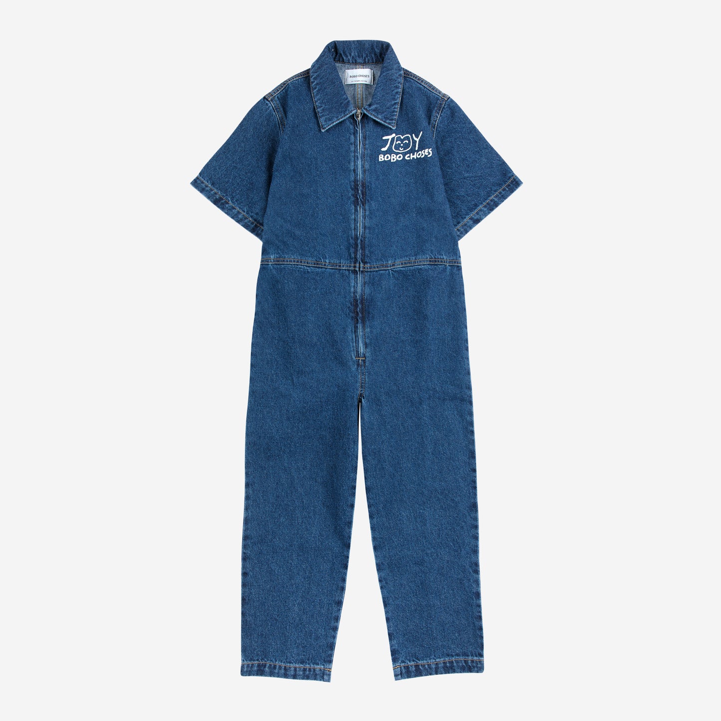 A children's short-sleeved denim jumpsuit laid flat against a white background. It is made from dark blue denim with a structured collar and a front zip closure. A white "JOY BOBO CHOSES" logo with a simple, smiling face is printed on the left chest. The jumpsuit has a relaxed fit with visible stitching details and slightly tapered legs.