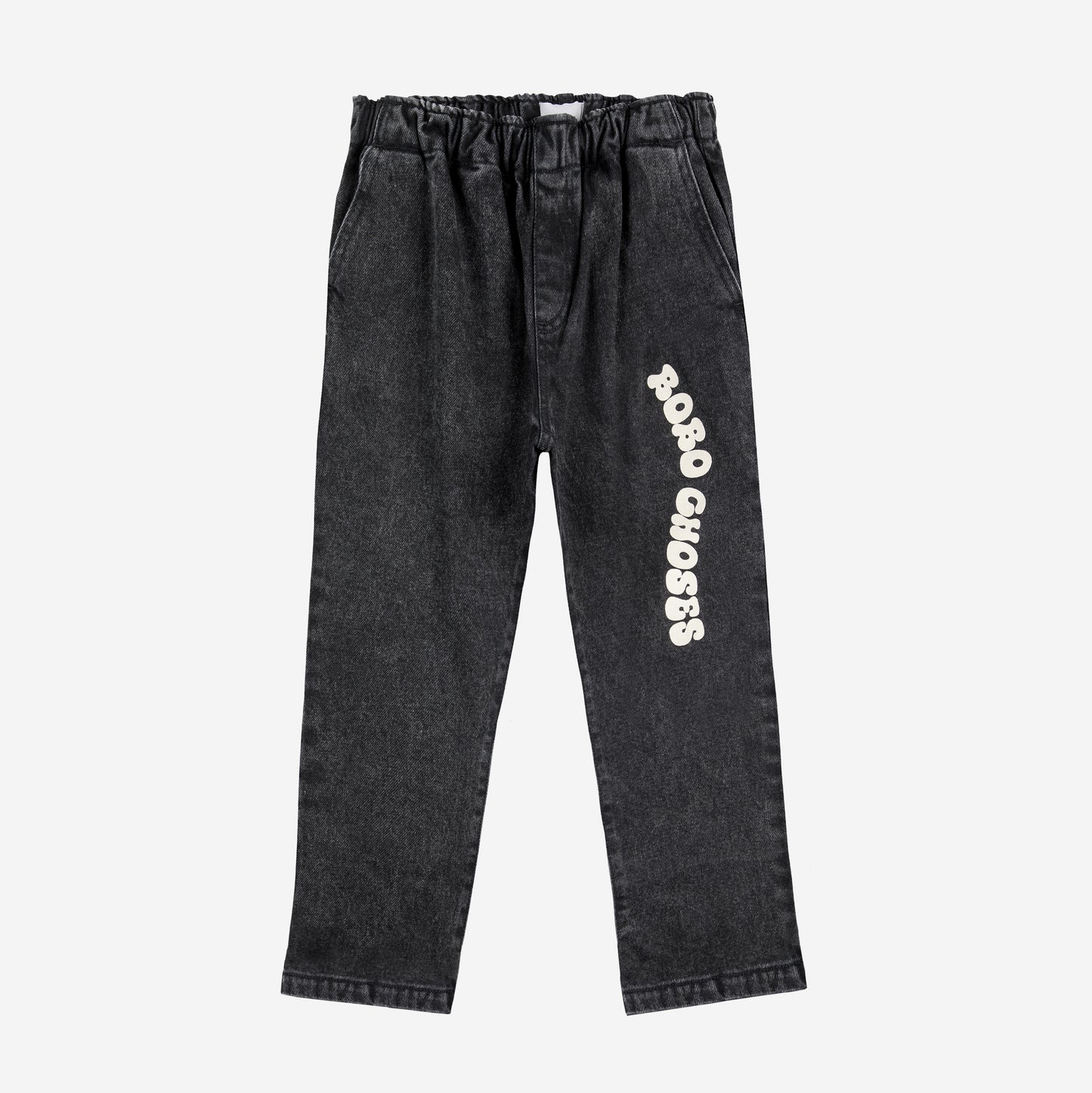 A pair of black denim trousers with an elasticated waistband and a relaxed, straight-leg fit. The left leg features a playful white "Bobo Choses" logo printed in a curved, bubbly font.