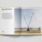 Open book showing a page with text and an image of a geometric sculpture on a grassy area.