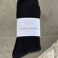 Black socks with a white label on a stone surface