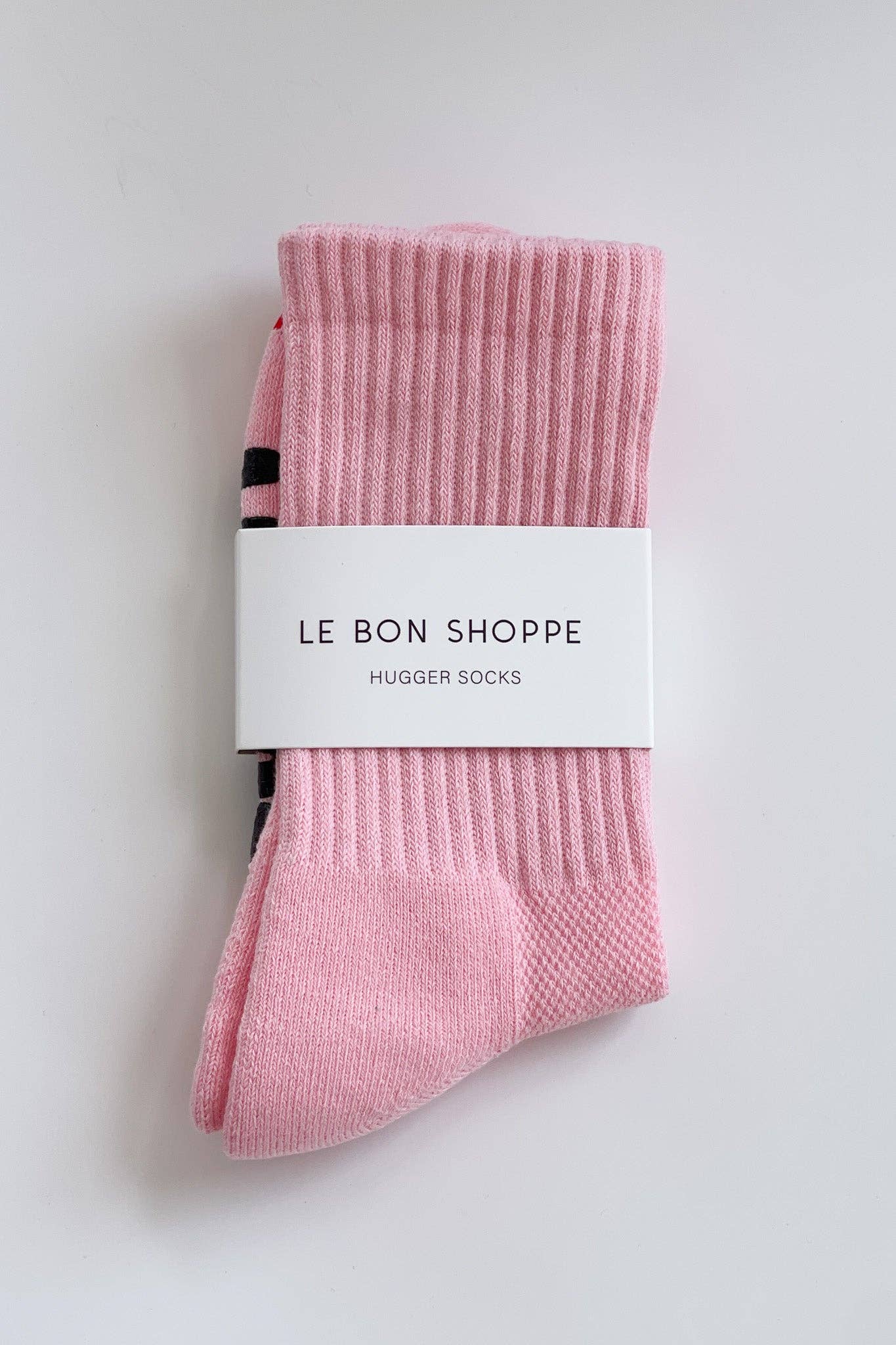 Pink socks with a white label on a light gray background