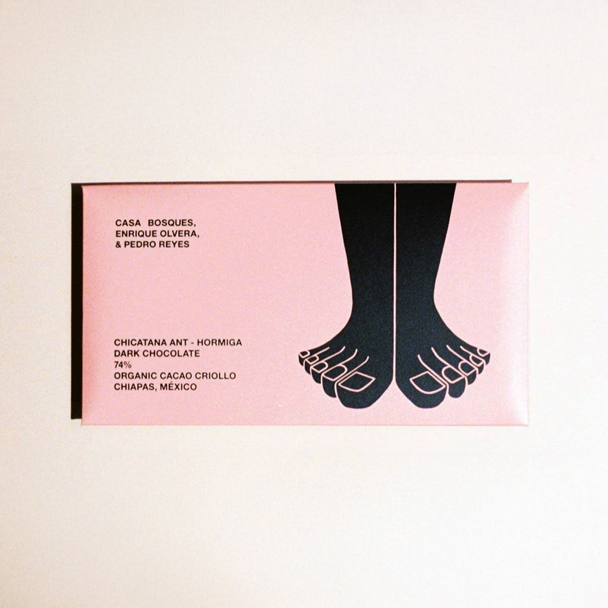 Chocolate bar packaging with foot illustration and text on a pink background