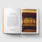 Open book with text on one page and a photograph of a room with 'MOTH' on the wall on the other page.
