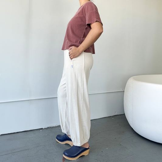 Full side view of Balloon Pants, styled with a cropped tee and clogs – The high-waisted silhouette pairs effortlessly with a vintage-wash tee and statement footwear.