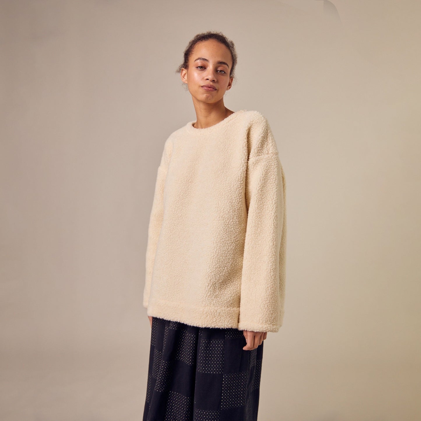 The Sideline Rosa Top, an oversized shearling sweatshirt from the AW24 collection. The top features a plush texture, offering warmth and comfort. Its relaxed silhouette ensures ample coverage, making it perfect for layering. The minimalist design adds versatility, allowing it to pair effortlessly with various outfits for a cozy winter look.