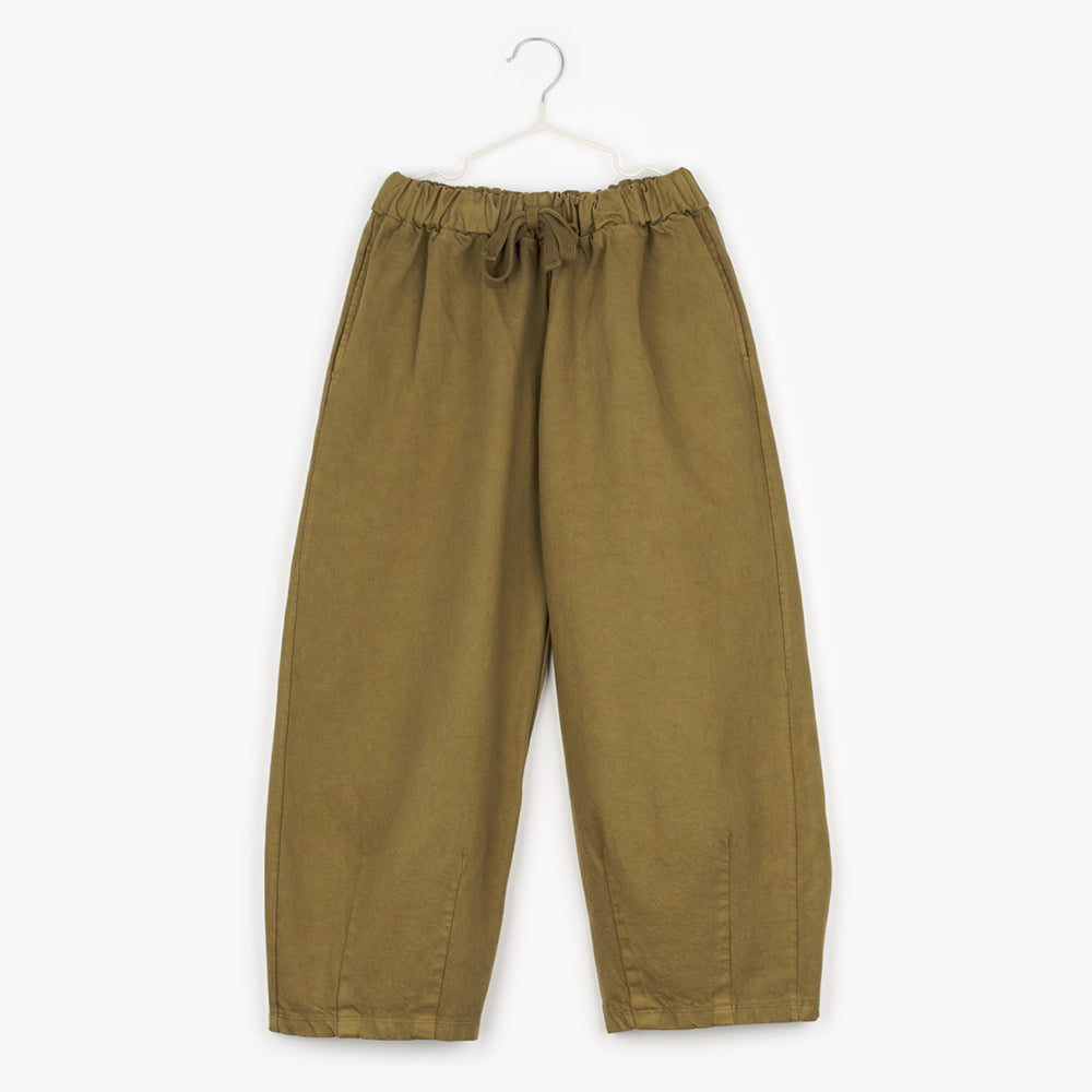 A pair of khaki trousers with and elasticated waist and a draw string. The trousers have a tapered ankle giving the trousers a balloon leg and shape. 