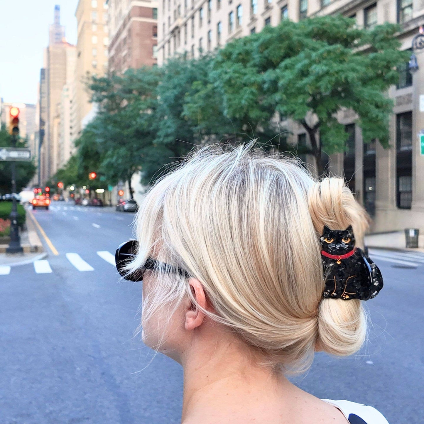 Person with blonde hair styled in a bun on a city street