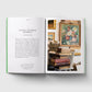 Open book showing a page with text and an image of a floral painting and books.