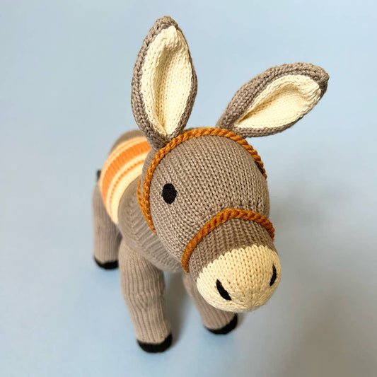 Knitted donkey toy with a blue background