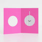 Open pink card with a white circle and a disco ball design on a light gray background