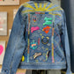 Denim jacket with colorful patches and embroidery on a blurred background