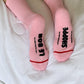 Pink socks with text on a white surface