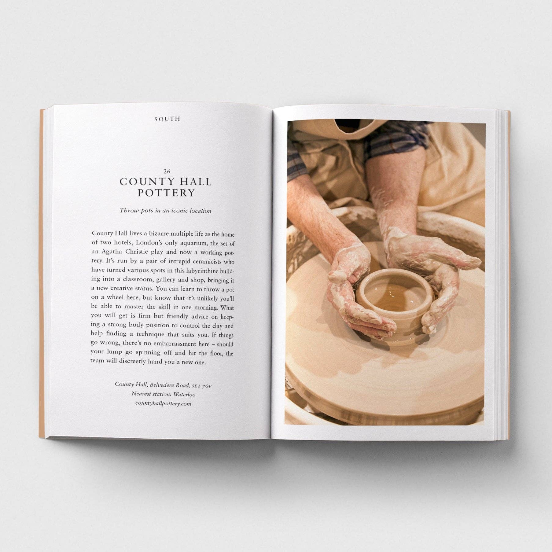 Open book showing a page with text and an image of hands working with clay on a potter's wheel.