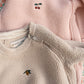 Two fleece jackets with embroidered designs on a floral background