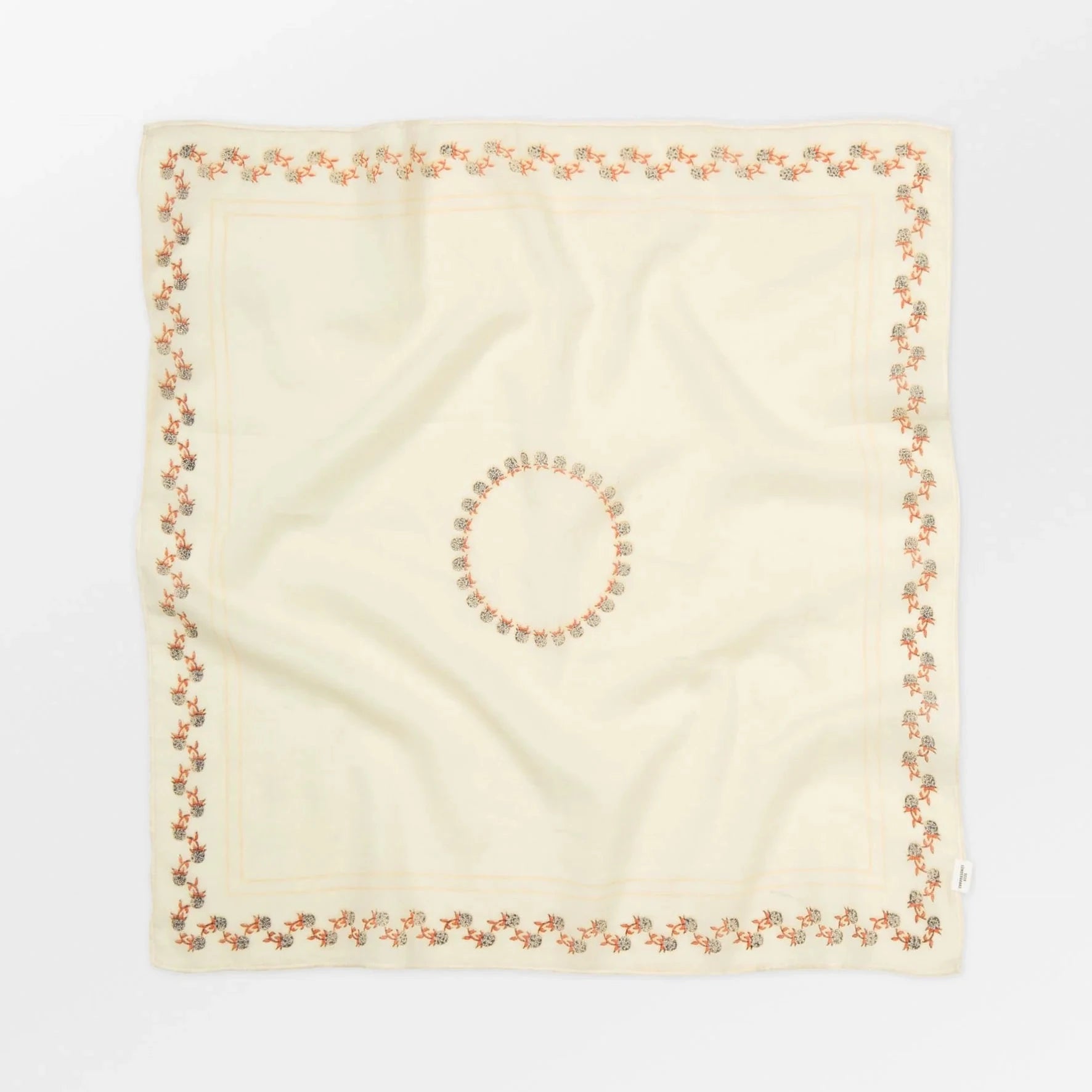 Beige square scarf with a circular pattern on a white background