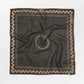 Black square scarf with decorative border on a white background