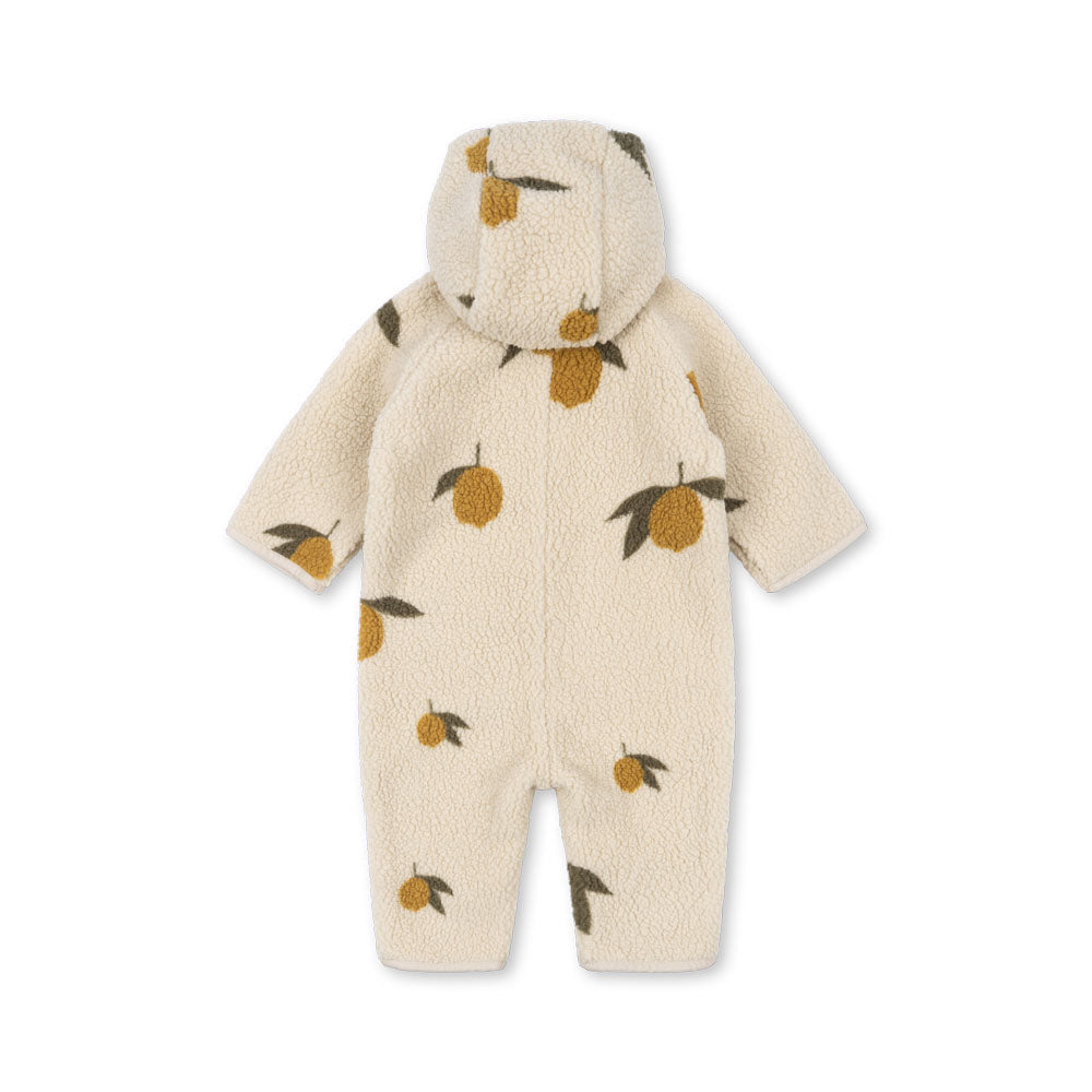 The Konges Sløjd Jody Teddy Onesie in a soft cream sherpa fabric, covered in their signature lemon print. Designed for ultimate coziness with a hood for extra warmth.